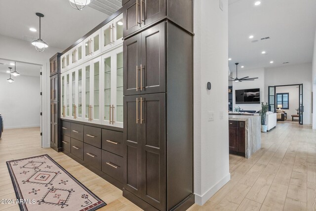 corridor with light wood-style floors, baseboards, and recessed lighting