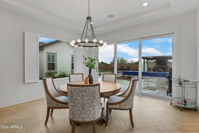 dining area featuring a tray ceiling, an inviting chandelier, baseboards, and recessed lighting