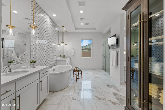 full bath featuring a stall shower, a raised ceiling, visible vents, and a sink