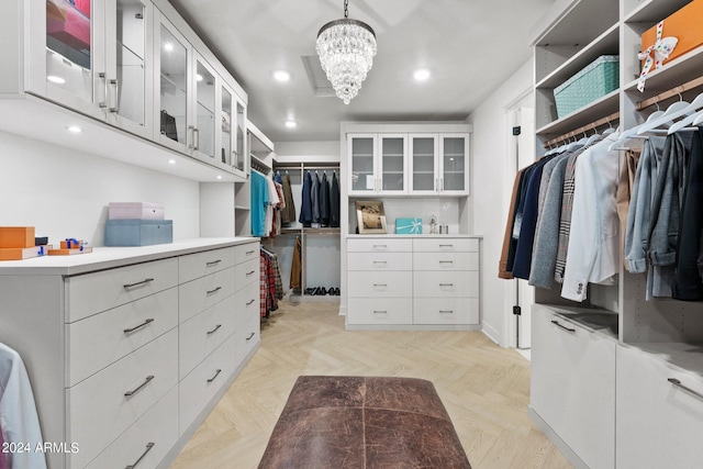 walk in closet with a notable chandelier