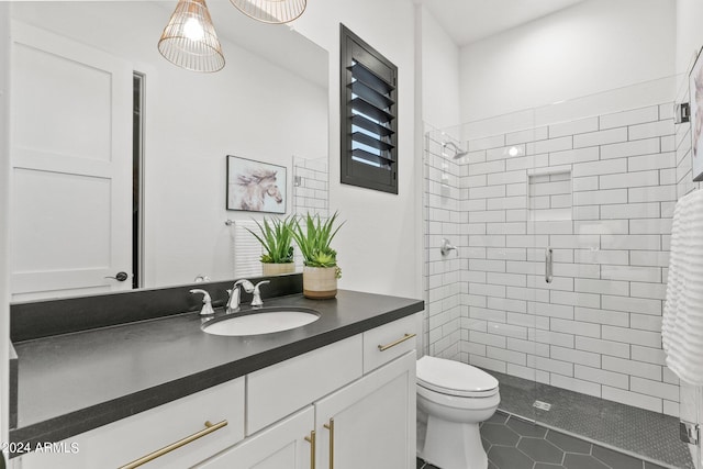 full bath featuring a stall shower, tile patterned flooring, vanity, and toilet