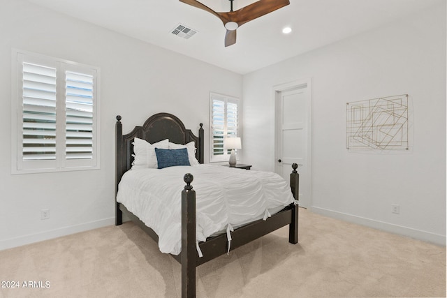 bedroom featuring light carpet, baseboards, visible vents, and a ceiling fan