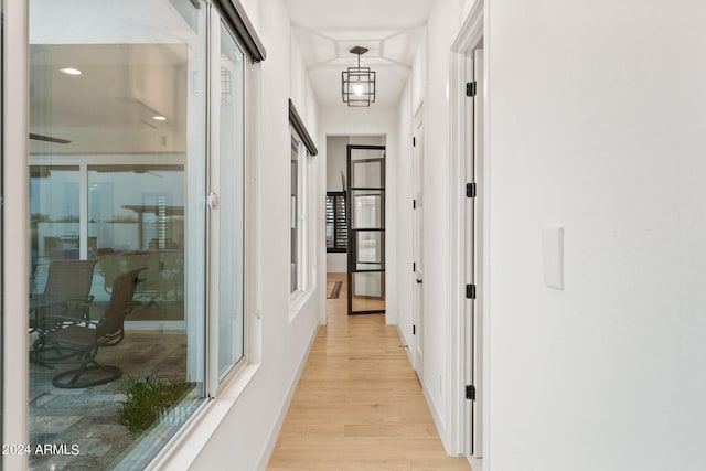 hall featuring light wood-style flooring and baseboards