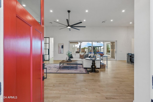 interior space featuring light wood-style floors, recessed lighting, ceiling fan, and a towering ceiling