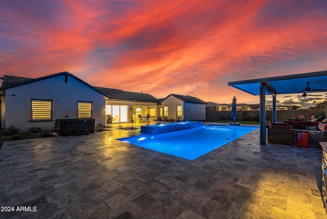 pool at dusk featuring a fenced in pool, a fenced backyard, and a patio