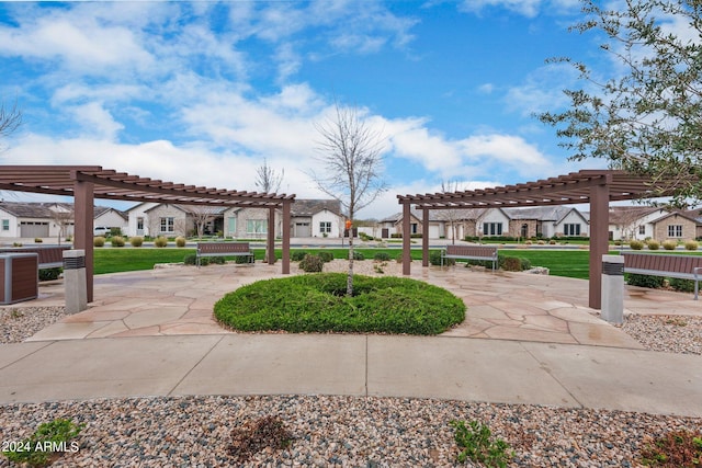 view of community featuring a residential view, a lawn, and a pergola