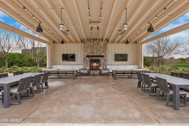 view of patio with outdoor dining space and an outdoor living space with a fireplace