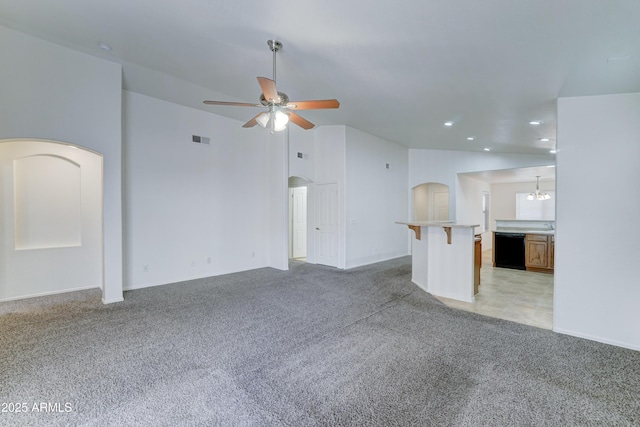 unfurnished living room with visible vents, ceiling fan with notable chandelier, recessed lighting, arched walkways, and light colored carpet