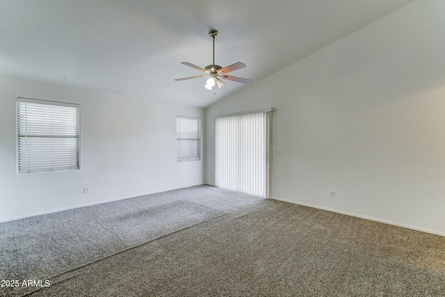 carpeted empty room featuring baseboards, lofted ceiling, a healthy amount of sunlight, and a ceiling fan