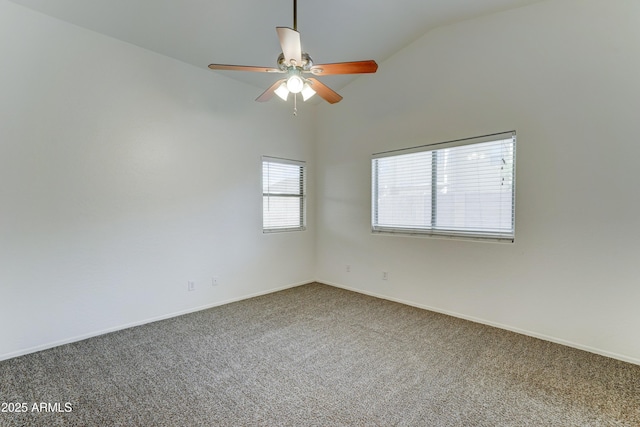 carpeted empty room featuring baseboards, ceiling fan, and vaulted ceiling