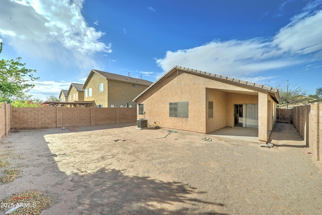 back of property with stucco siding, central air condition unit, a patio, and a fenced backyard