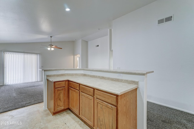 kitchen with visible vents, light carpet, open floor plan, light countertops, and lofted ceiling