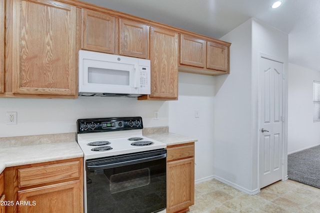 kitchen featuring baseboards, range with electric cooktop, white microwave, and light countertops