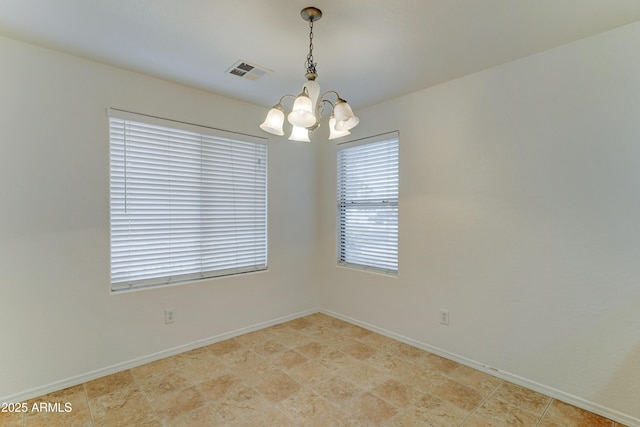 empty room featuring visible vents, baseboards, and a notable chandelier