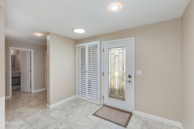 foyer with light marble finish floors and baseboards
