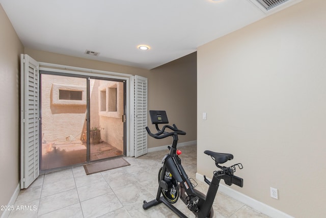 exercise room with baseboards and tile patterned floors