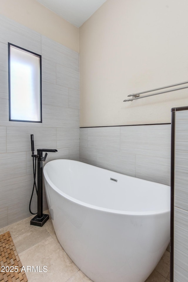 full bathroom with tile walls, a soaking tub, and tile patterned floors