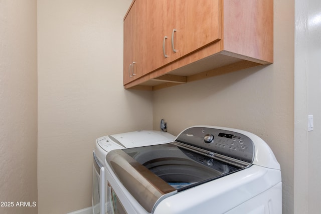 laundry area featuring washer and dryer and cabinet space