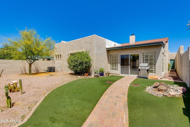 back of house featuring stucco siding, a chimney, and central air condition unit