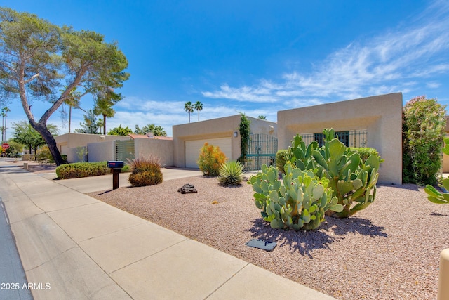pueblo-style home featuring stucco siding and a garage