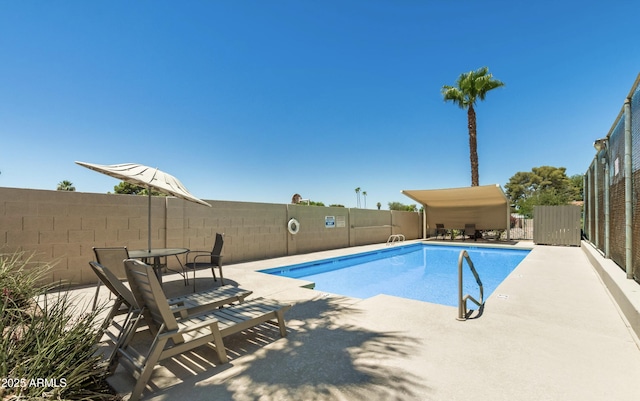 community pool featuring a fenced backyard and a patio area