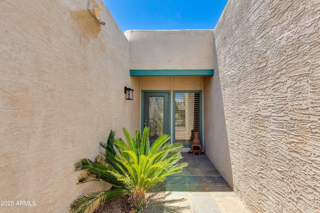 doorway to property featuring stucco siding