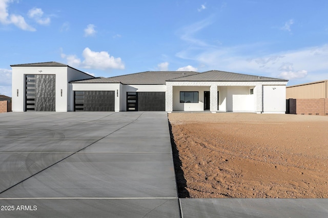 view of front of home featuring a garage, concrete driveway, and stucco siding