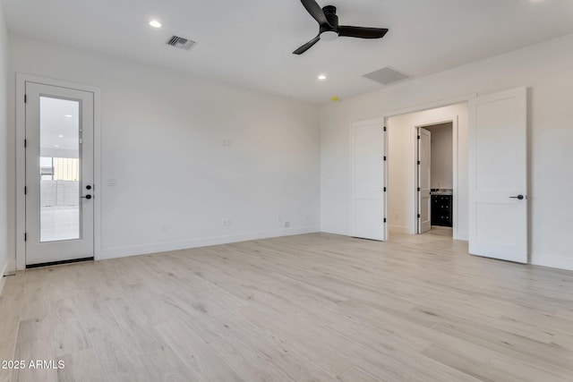 spare room with light wood-style floors, ceiling fan, and visible vents