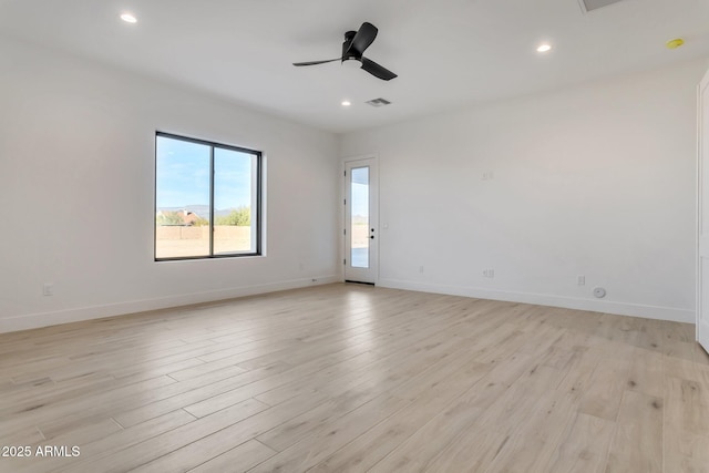 unfurnished room with light wood-style floors, visible vents, ceiling fan, and baseboards