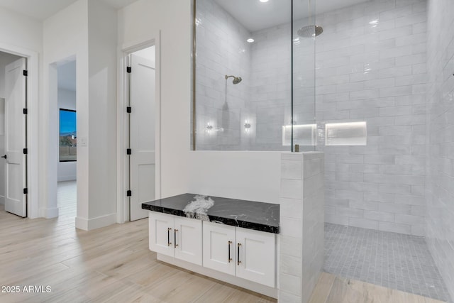 full bathroom with a walk in shower, wood finished floors, and vanity