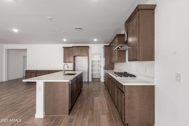 kitchen featuring appliances with stainless steel finishes, sink, dark hardwood / wood-style flooring, and a kitchen island with sink