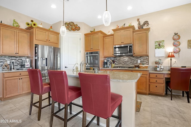 kitchen with appliances with stainless steel finishes, hanging light fixtures, and backsplash