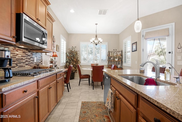 kitchen with appliances with stainless steel finishes, visible vents, a sink, and hanging light fixtures