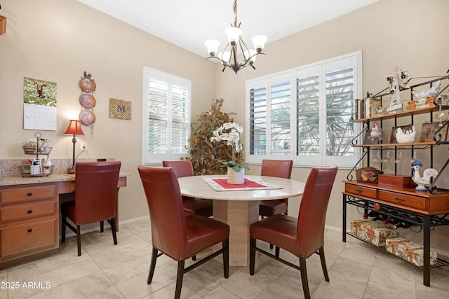 dining area featuring a notable chandelier, built in desk, baseboards, and light tile patterned floors