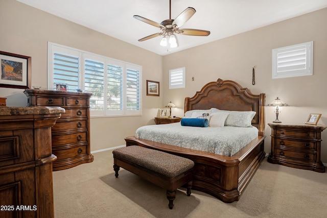 bedroom featuring light carpet, a ceiling fan, and baseboards