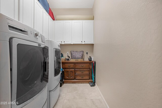 washroom with separate washer and dryer, light tile patterned flooring, cabinet space, and baseboards