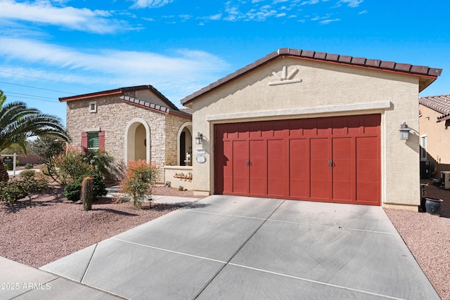 mediterranean / spanish-style home with stone siding, concrete driveway, and stucco siding