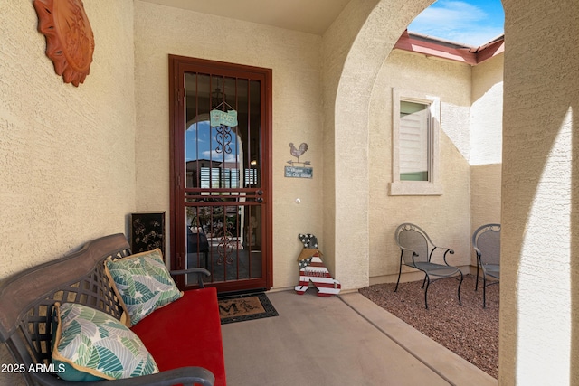 property entrance with a patio and stucco siding