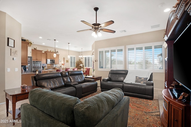 living room featuring recessed lighting, visible vents, light tile patterned flooring, and ceiling fan with notable chandelier