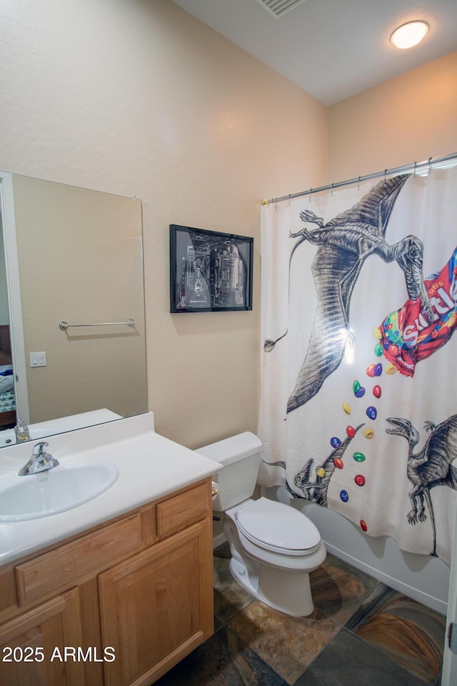 14045 E Geronimo Rd, Scottsdale, AZ 85259 - full bathroom featuring vanity, shower / bath combo with shower curtain, stone finish floor, and toilet