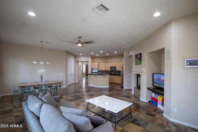 14045 E Geronimo Rd, Scottsdale, AZ 85259 - living area with ceiling fan, a glass covered fireplace, recessed lighting, baseboards, and visible vents