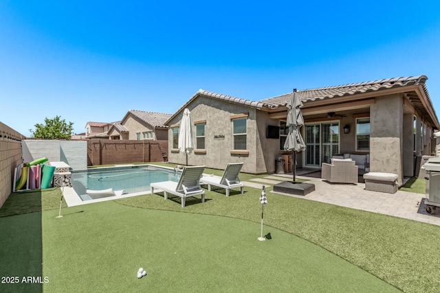 view of swimming pool featuring a putting area, a patio, a ceiling fan, and a fenced backyard