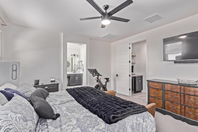 bedroom with light colored carpet, connected bathroom, and a ceiling fan