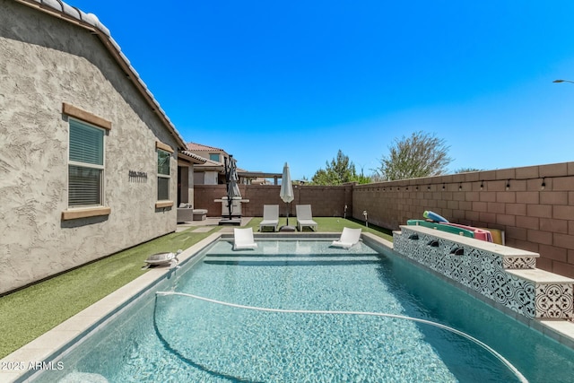 view of pool with a fenced backyard
