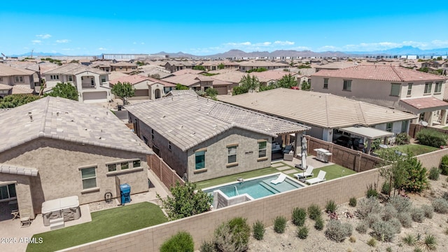aerial view of residential area with a mountain backdrop and a pool area