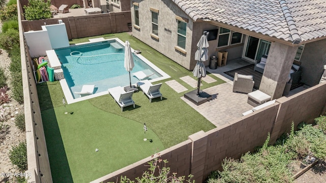 view of pool featuring an area to practice putting, a fenced backyard, and a patio