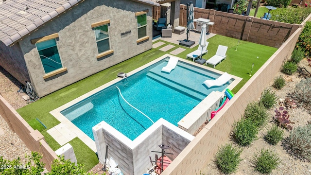 view of pool featuring a water slide, a patio, a fenced backyard, and a putting area