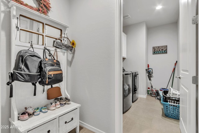 mudroom with independent washer and dryer and light tile patterned floors