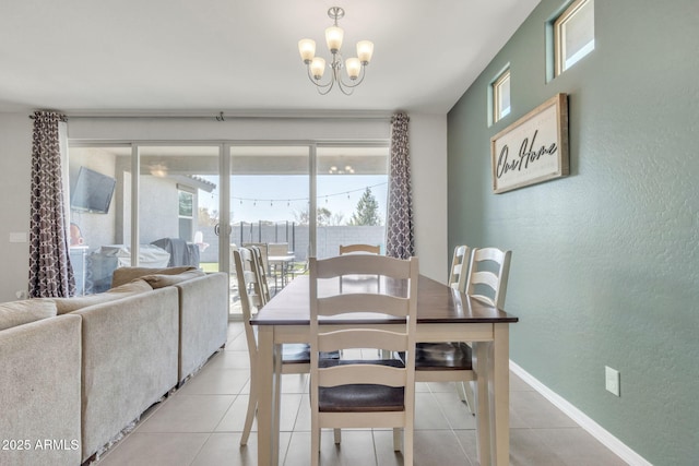 dining area with light tile patterned flooring and an inviting chandelier