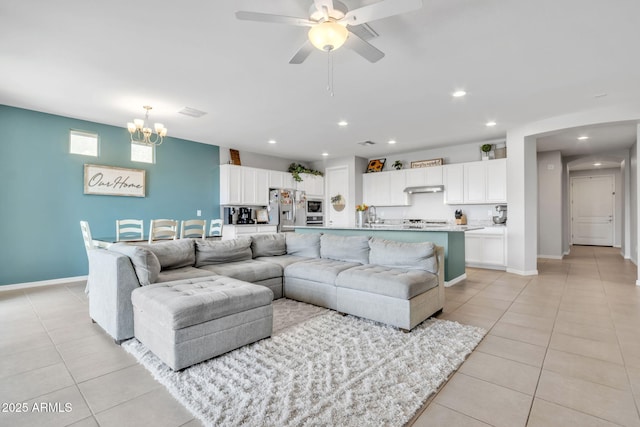 living room with ceiling fan with notable chandelier, sink, and light tile patterned floors